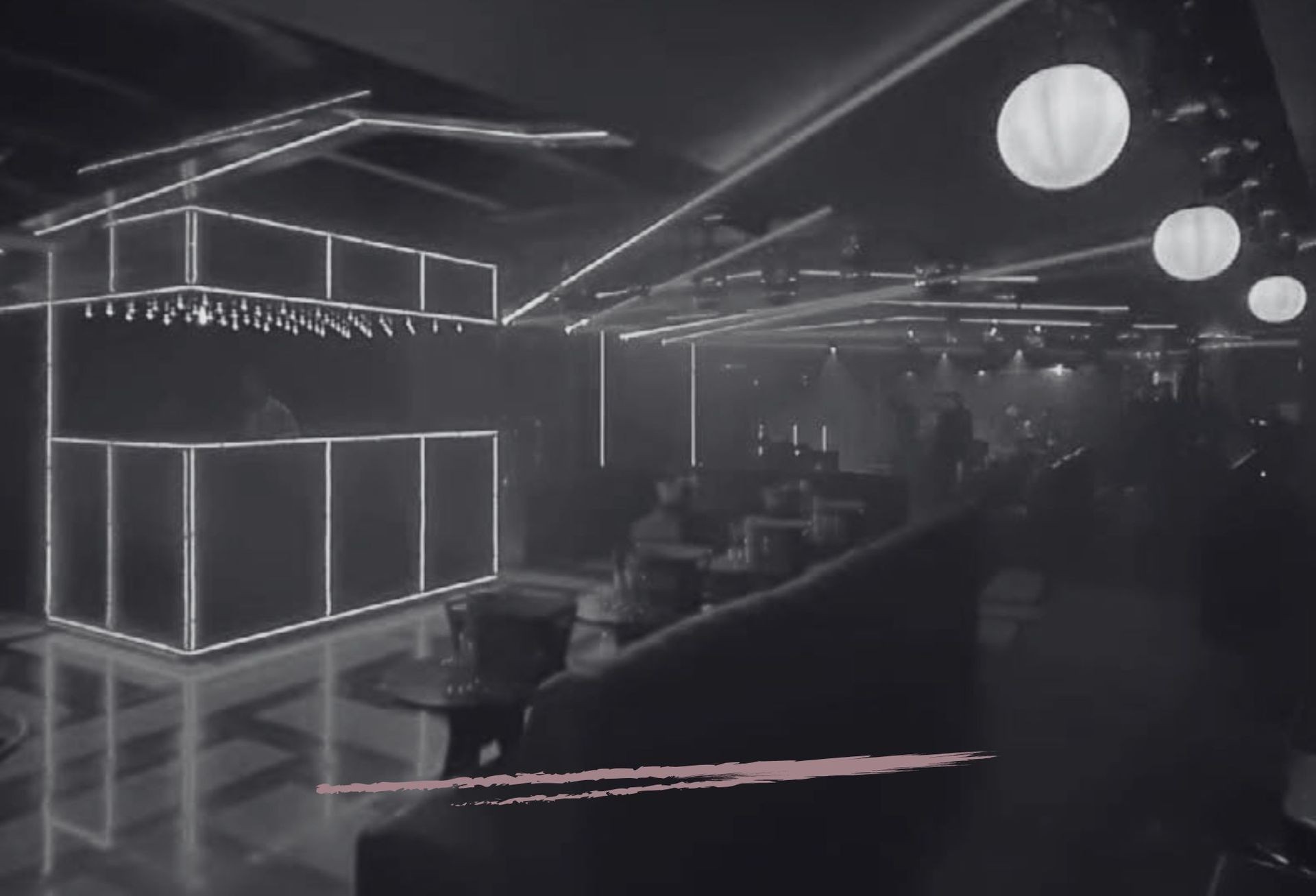 Interior of a dimly lit nightclub with glowing light fixtures and modern decor.